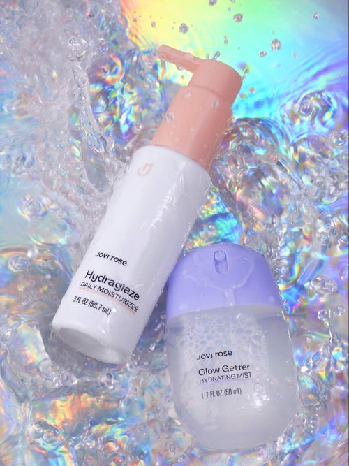 Two skincare bottles on a colorful, water-textured background